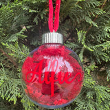 Red Christmas ornament with 'Alfie' on a tree